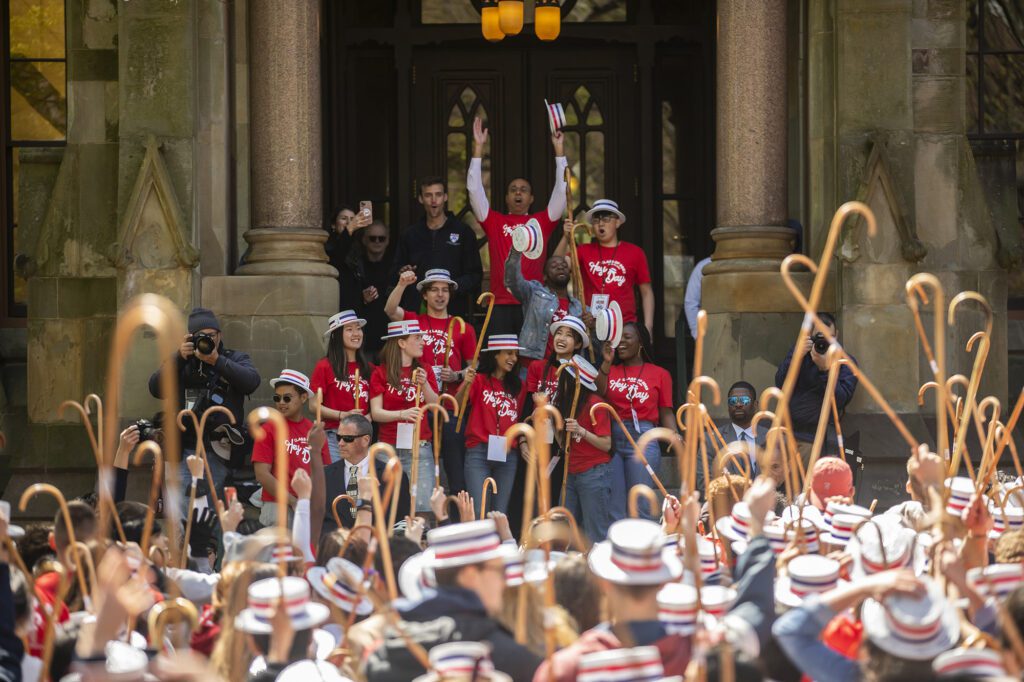 Students raising hats and canes during the annual Hey Day event honoring rising juniors