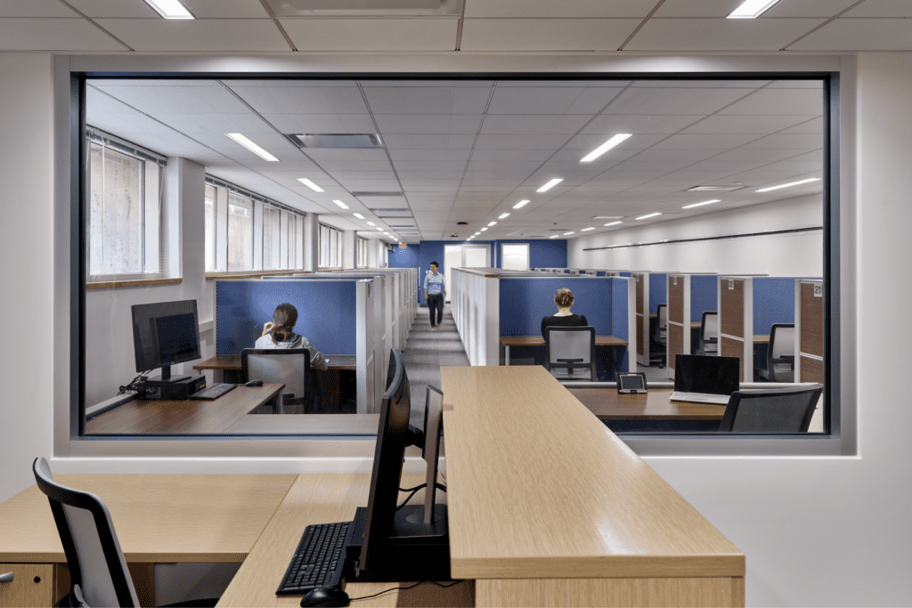 Students are taking tests in the cubicle-filled room.