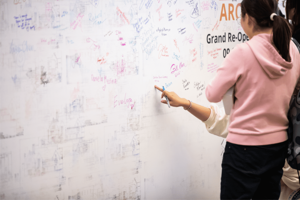 A student points to a name on the wall