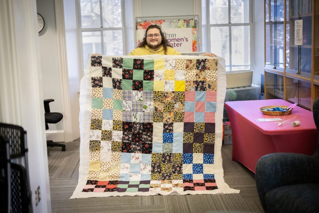 Luke holds his hand made quilt