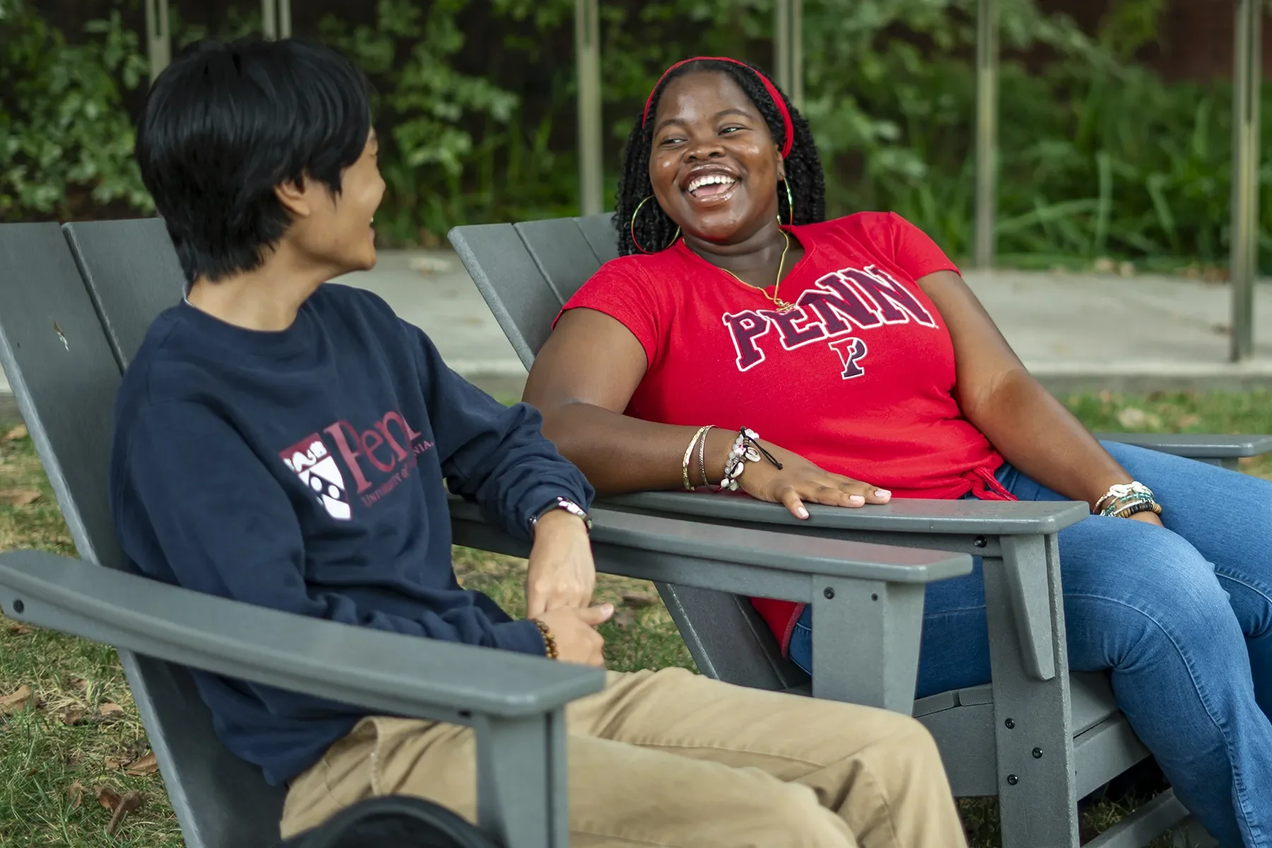Students sitting outside and laughing with each other.