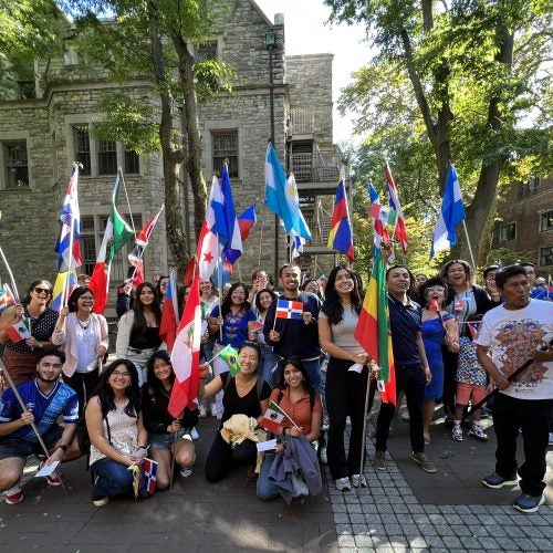 Latinx/e students and staff walk along locust walk during the Procession of Flags event